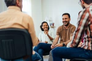 An adult man, looking happy, talking about mental health